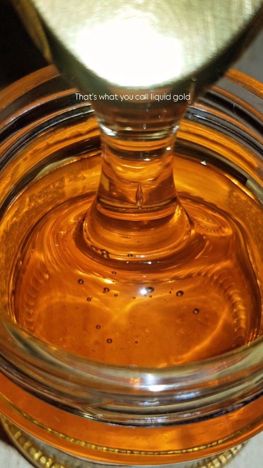 Raw honey close up, a golden drop with wax visible.