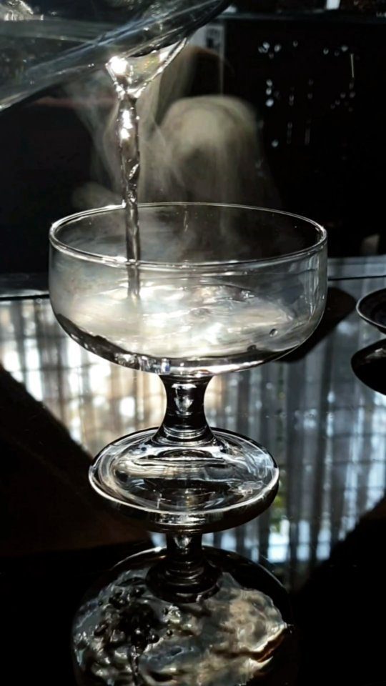A spoon of honey holding its shape in a glass of water.